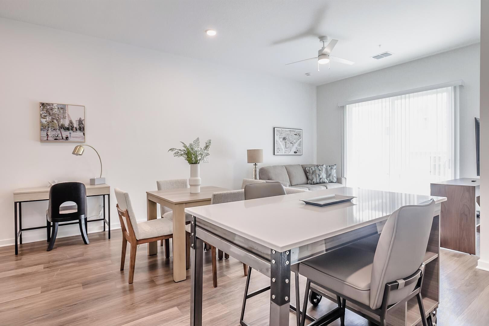 Una habitación moderna y bien iluminada con una mesa de comedor, sillas, un sofá y un televisor.