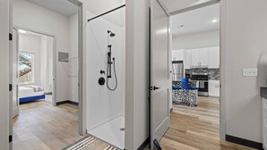 A modern apartment with a shower, a kitchen, and a bedroom with a view. - Sunny 1BR Apt Near Music Scene! (Nashville)