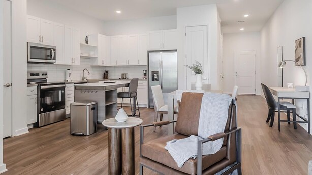 A modern kitchen with white cabinets, stainless steel appliances, and a central island. - Landing | Stylish 3BD, Gym (Four Corners)