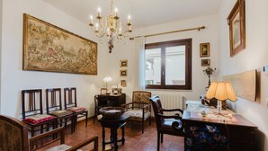 Ein Essbereich mit einer Kronleuchter, Stühlen, einem Tisch und einem großen Gemälde an der Wand.