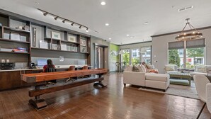 Een moderne kantoorruimte met een lange houten bank, een receptiebalie en een zithoek met een bank en stoelen.