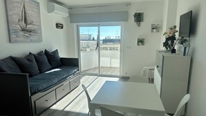 Een moderne woonruimte met een bank, een eettafel en een televisie.