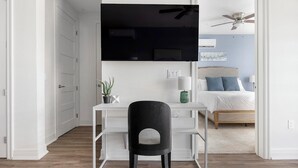 Een moderne slaapkamer met een bed, een bureau en een stoel.