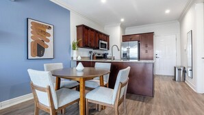 Een moderne keuken met donkere houten kastjes, roestvrijstalen apparatuur en een centraal eiland.