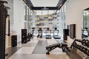 Ein modernes Fitnessstudio mit Laufbändern, Kraftgeräten und Kurzhanteln.