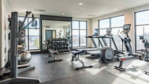 Ett modernt gym med löpband, crosstrainers och fria vikter.