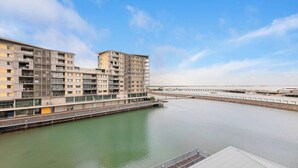 A modern apartment building with multiple balconies, a waterfront view, and a dock extending into the water. - Lagoon Panorama Relaxed Waterfront Escape near CBD (Darwin)