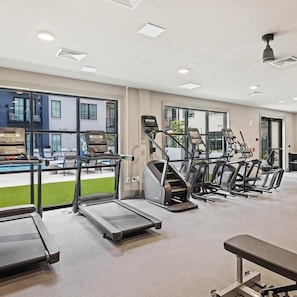 A gym with treadmills, stationary bikes, and a bench. - Landing | Spectacular 2BD, Gym, Yoga Studio (Savannah)