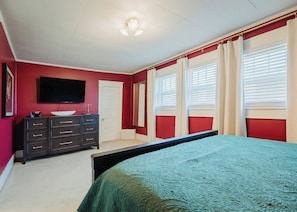 A bedroom with a bed, dresser, TV, and windows with blinds. - New listing! Historic 4 bedroom home in Russellville! (Russellville)