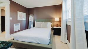 Ein Hotelzimmer mit einem Bett, einem Nachttisch, einer Lampe und einem Spiegel.