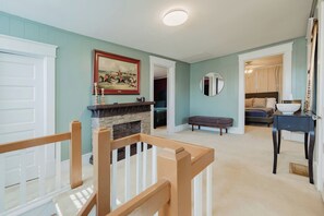 Una habitación con chimenea, un banco, una cama y un comedor.