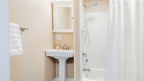 Ein Badezimmer mit Waschbecken, Spiegel und Dusche.