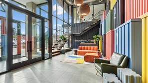 A modern interior with a staircase, seating area, and large windows. - Landing | Amazing 1BD, Yoga Studio, Gym (Durham)
