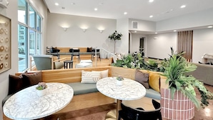 Un espace de détente moderne, doté de sièges, de tables et de plantes en pot.