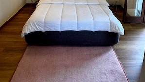 Une chambre avec un grand lit, deux tables de chevet et une fenêtre.