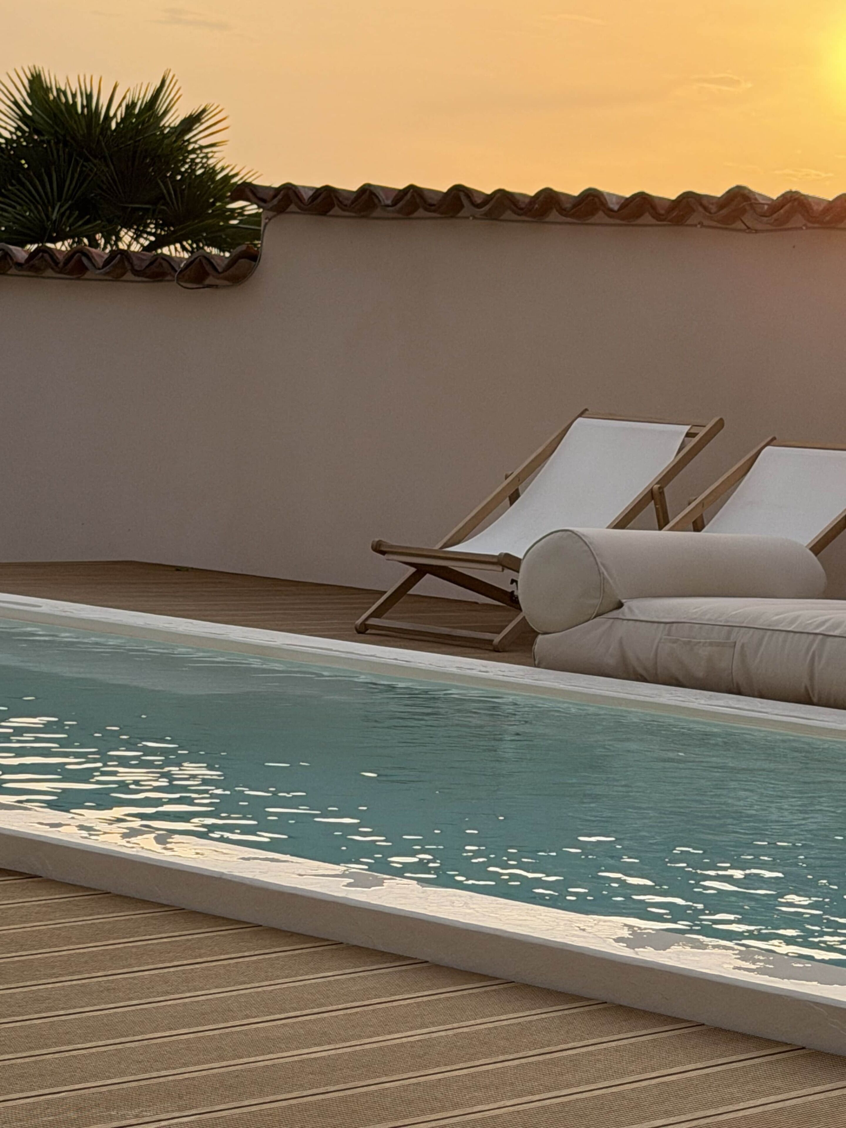 A poolside area with lounge chairs and a tiled deck.