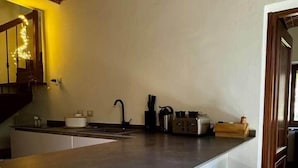 Une cuisine dotée d’un îlot central, d’un évier et de deux tabourets.