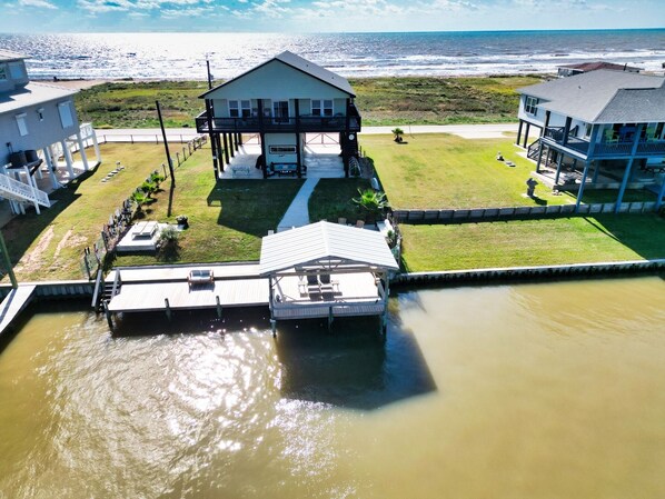 Una propiedad frente al mar con una casa que tiene balcón, muelle y vista al océano.