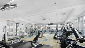 A gym with cardio machines, weight stations, and a large mirror. - Landing | Spectacular 1BD, Pool, Courtyard (Raritan)