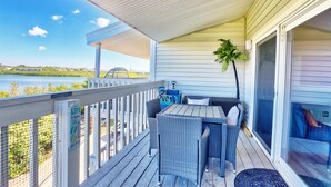 A covered outdoor deck with a table and chairs, overlooking a body of water. - The Intercoastal #209 - Intercoastal Escape (Indian Shores)