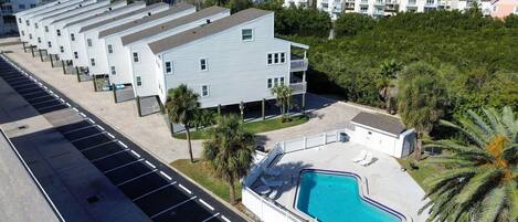 A modern hotel with a pool area, multiple balconies, and a view of the ocean.