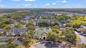 A residential area with multiple houses, a swimming pool, and a parking lot. - Landing | Stunning 1BD, Courtyard, Clubhouse (Austin)
