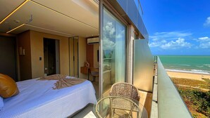 Un dormitorio con cama, una silla y un balcón con vistas al océano.
