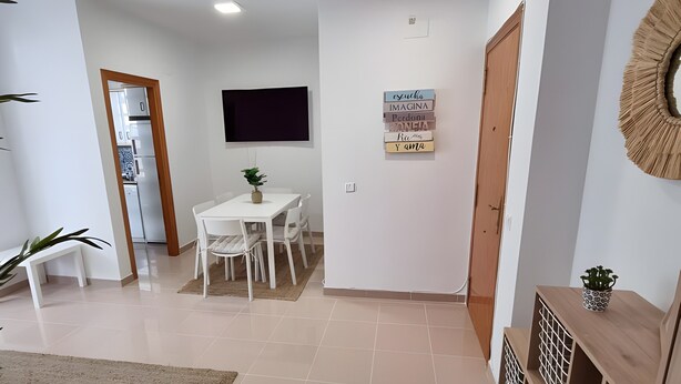 A modern living room with a dining area, a television, and a wooden cabinet.