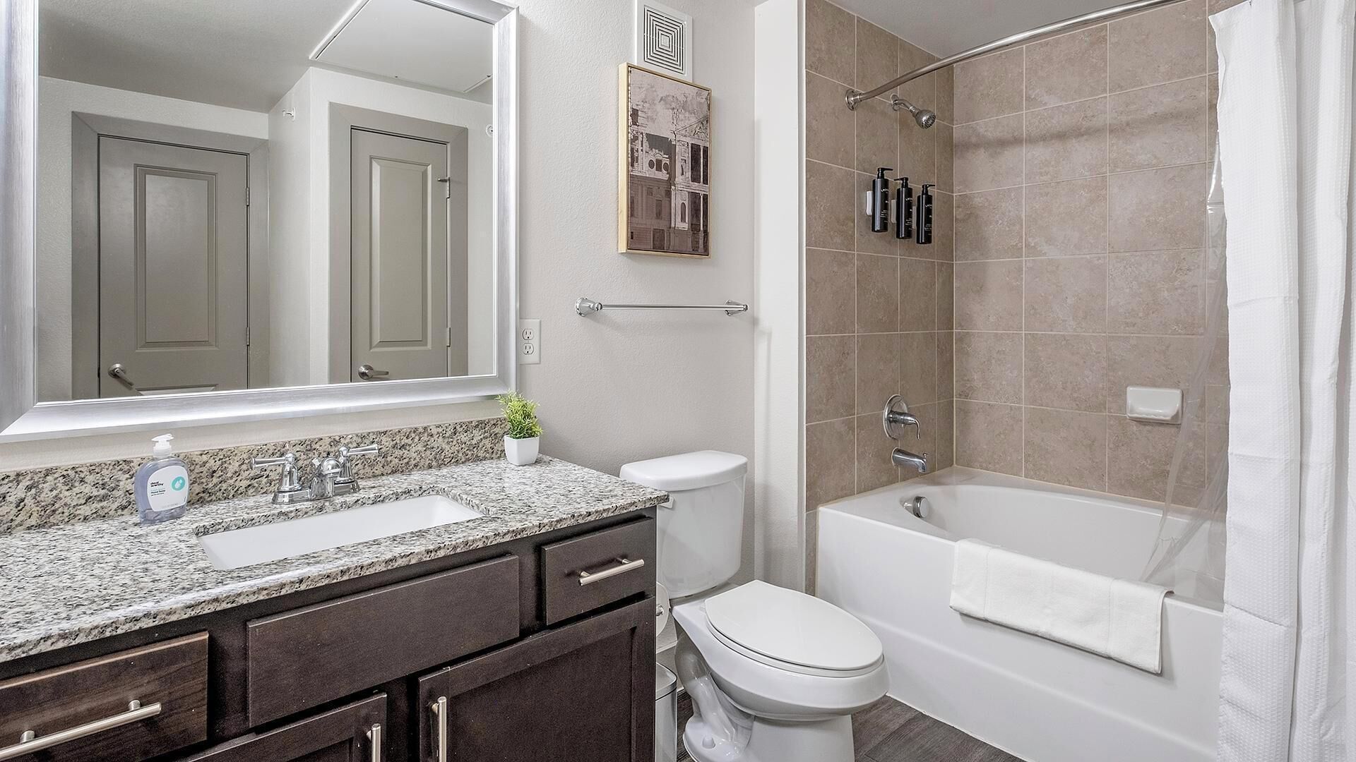 Un baño con lavamanos, inodoro y bañera.