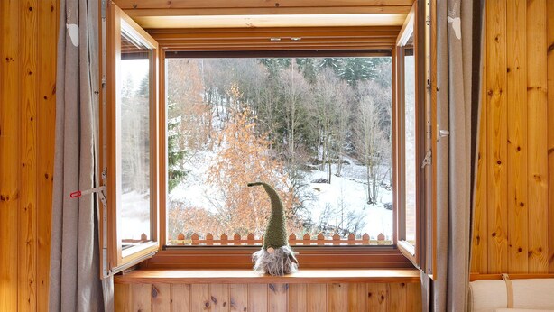 A wooden cabin interior with a window view of a snowy forest. - Holiday Home 'La Maisonnette' with Mountain View, Private Garden & Wi-Fi (Maisonasse)