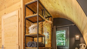 A wooden interior with a built-in shelving unit, a desk with a chair, and a small kitchenette area. - Tiny Home 'Le Pod 3' with Mountain View, Wi-Fi and Air Conditioning (Touët-sur-Var)