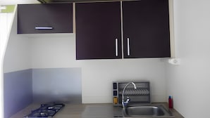 A compact kitchenette with a gas stove, sink, and dark cabinets. - Holiday Home 'Chalet 1 À 6 Personnes Pmr Access' with Private Terrace and Wi-Fi (Touët-sur-Var)