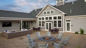 Une terrasse avec un foyer, des sièges et un téléviseur.