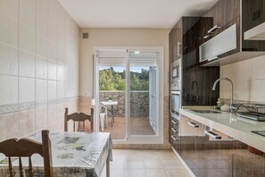 Una cocina con comedor, horno empotrado y vistas al exterior.