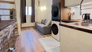 Un espacio habitable compacto con cocina, comedor y sofá.