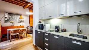 A modern kitchen with a wooden dining table and chairs, a built-in microwave, and a stainless steel sink. - YiD Lungarno Cellini retreat (Florence)