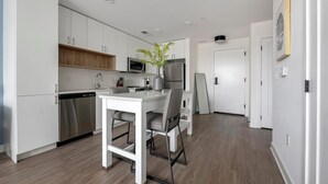 Una cocina moderna con armarios blancos, electrodomésticos de acero inoxidable y una isla central.