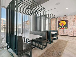 A modern dining area with a glass partition, black metal railings, and a patterned wall. - Landing | Modern 2BD, Gym, Clubhouse (Denver)