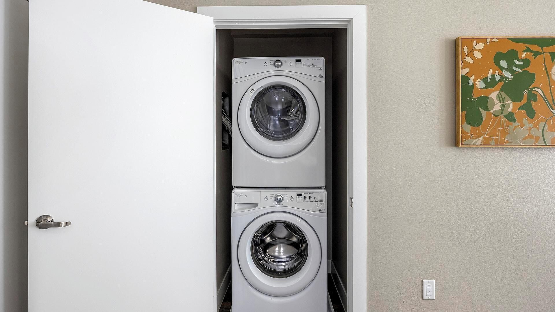 A laundry room with two stacked front-loading washing machines.