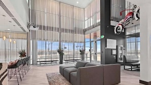 A spacious lobby with a large seating area, a high ceiling, and a view of the outdoors. - Landing | Modern 2BD, Gym, Clubhouse (Denver)