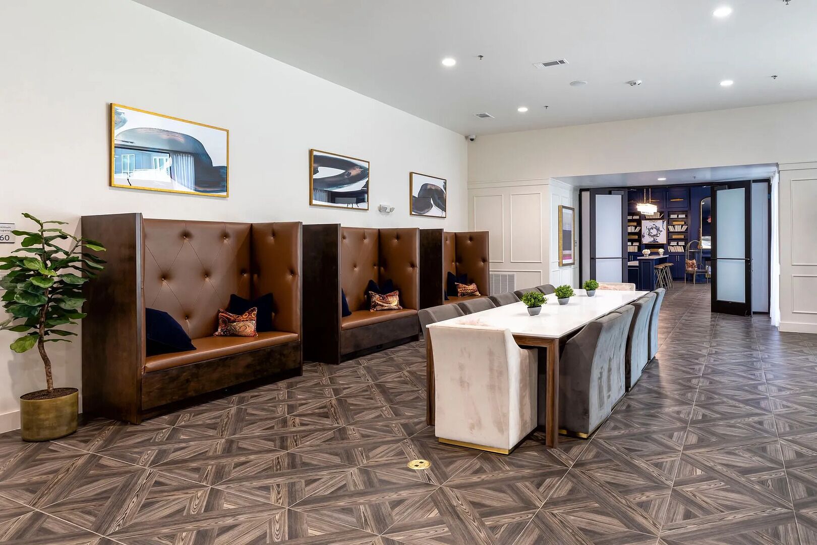 A modern hotel lobby with a long reception desk, seating areas with cushioned benches, and a patterned floor.