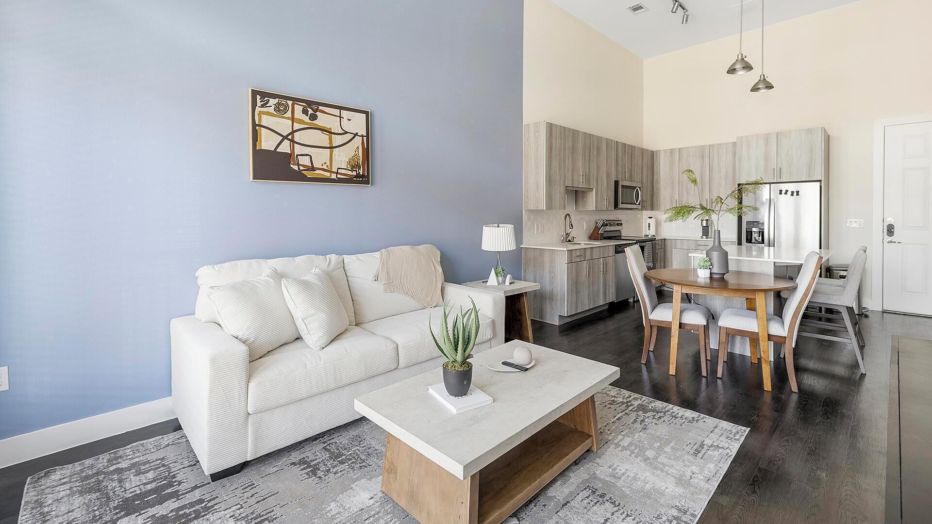Ein modernes Wohnzimmer mit Sofa, Couchtisch und Kunstwerk an der Wand.