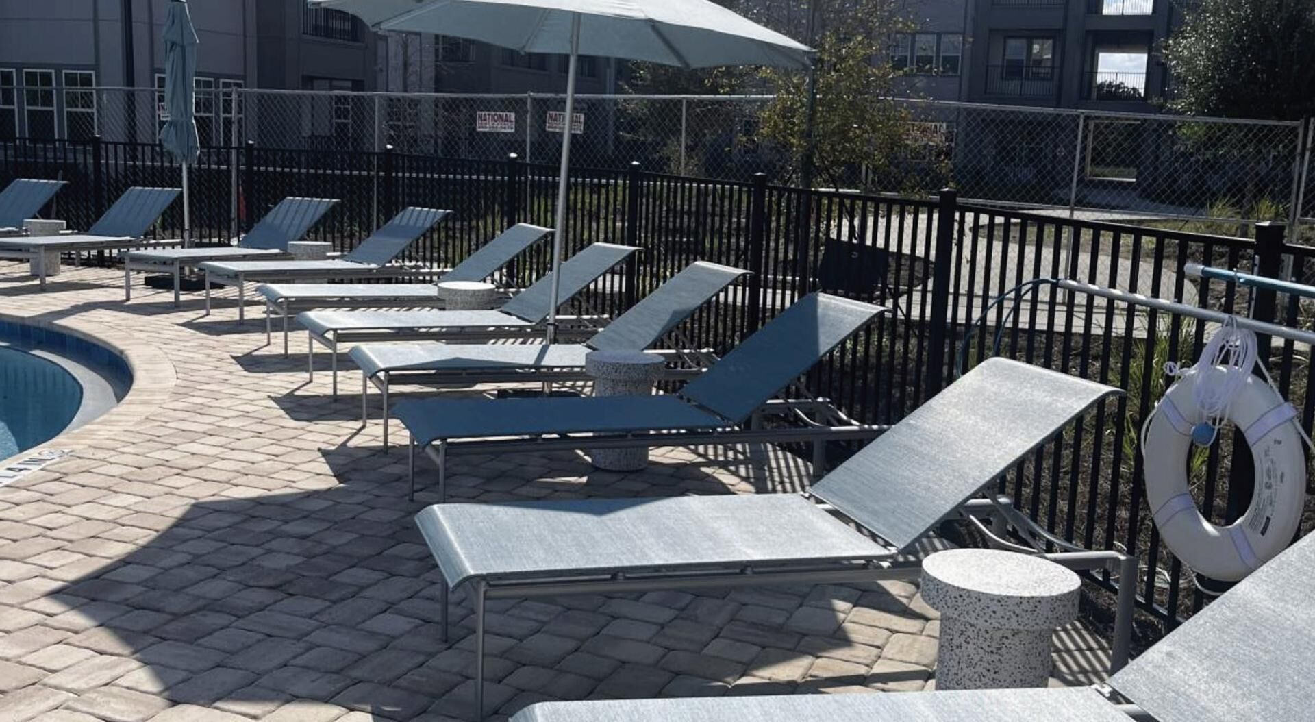 Un espace aménagé au bord de la piscine, avec des chaises longues et une bouée de sauvetage.