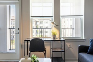 A small, well-lit room with a desk, chair, and a potted plant. - Landing | Spectacular 2BD, Yoga Studio (Kissimmee)
