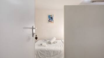 Ein Hotelzimmer mit einem Bett, einer Tür und einer Wand mit einem Poster.