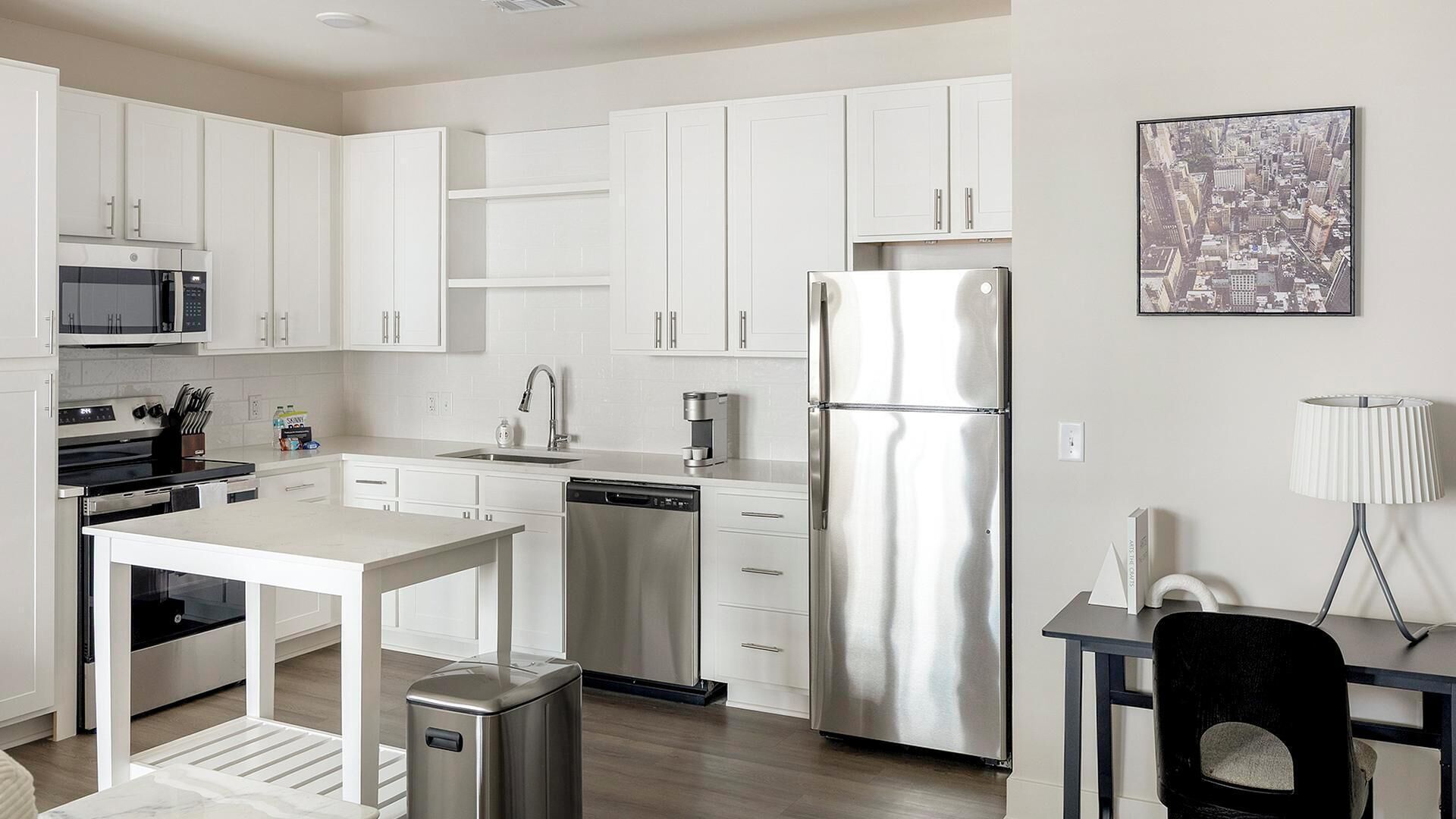 A modern kitchen with white cabinets, stainless steel appliances, a dishwasher, and a refrigerator.