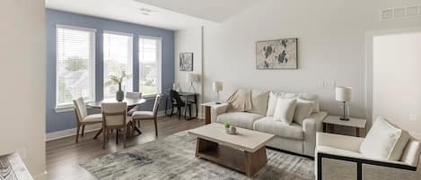 Una sala de estar moderna con sofá, mesa de centro y comedor.