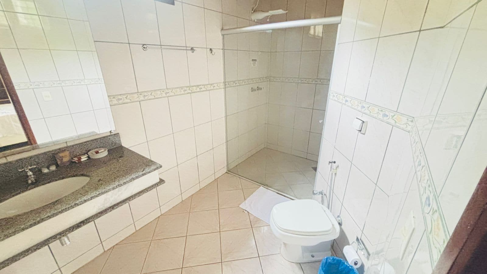 A bathroom with a sink, toilet, and shower area.