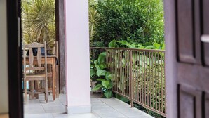 An indoor area with a tiled floor, wooden furniture, and a metal railing. - Chalés Casa Rosa (Alto Paraíso de Goiás)
