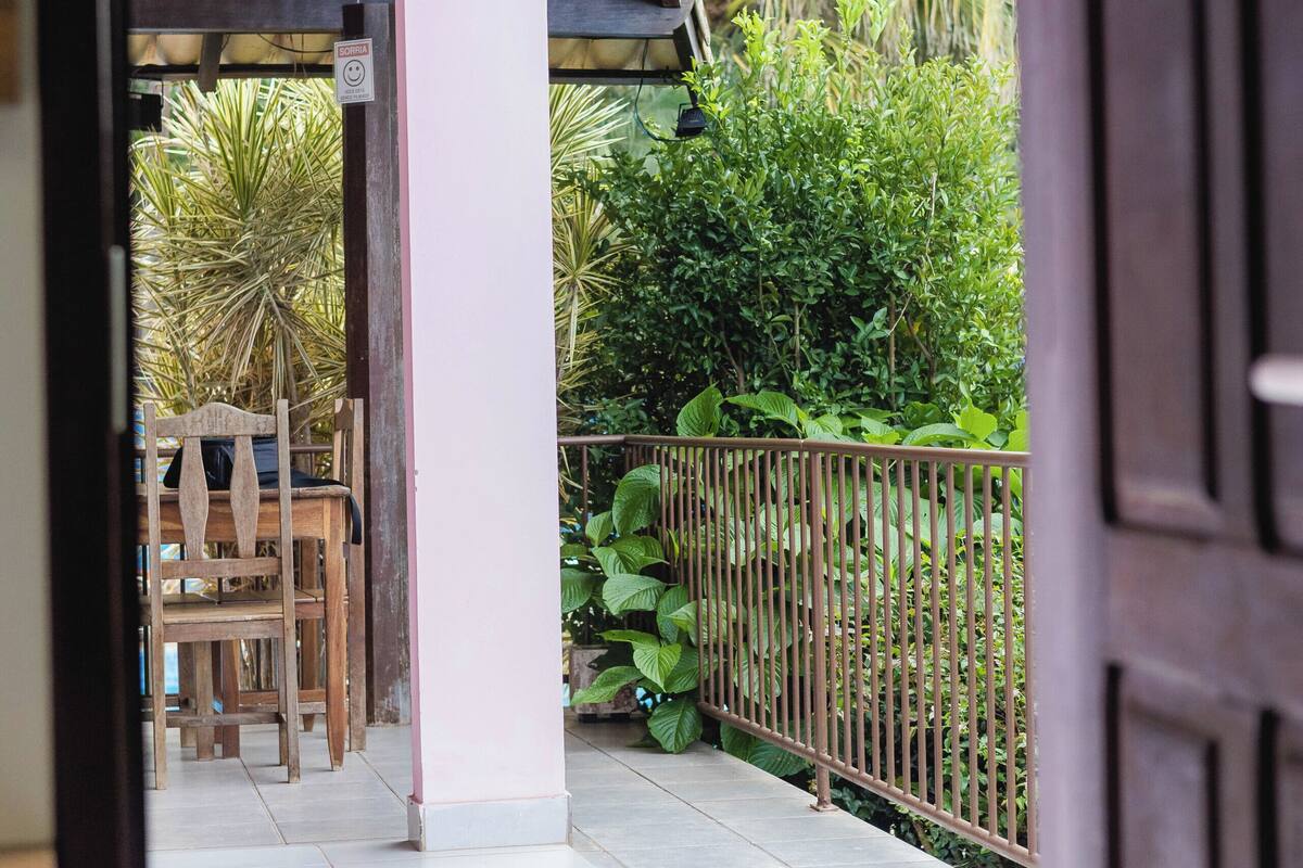 An indoor area with a tiled floor, wooden furniture, and a metal railing.